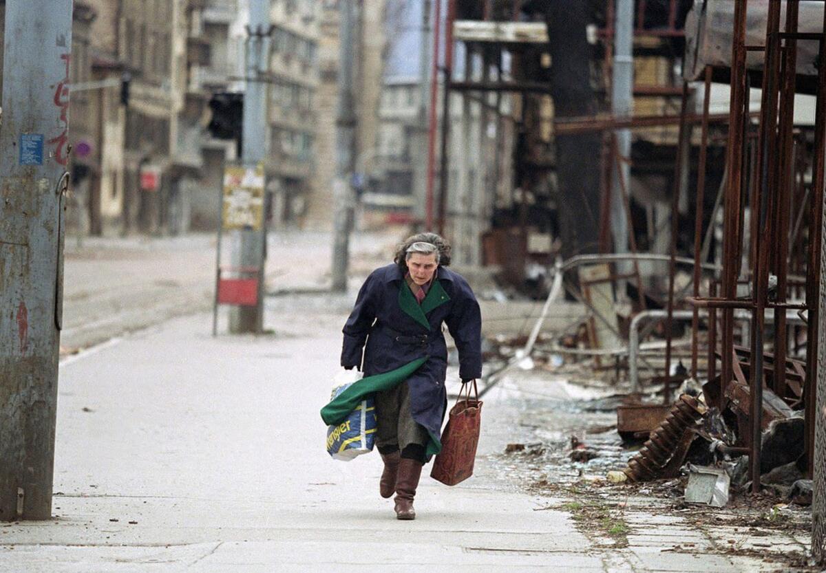 Женщина бежит по улице Zmaja od Bosne