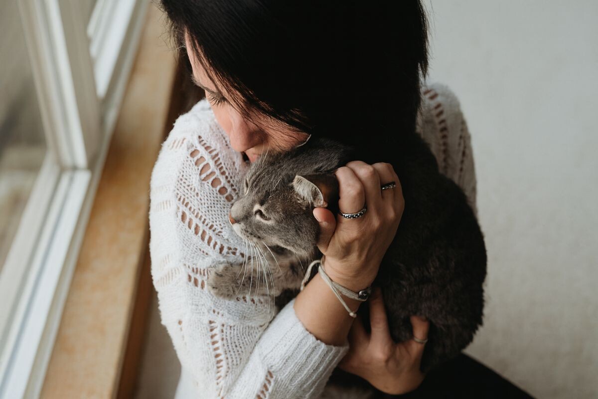 Женщина обнимает кошку 