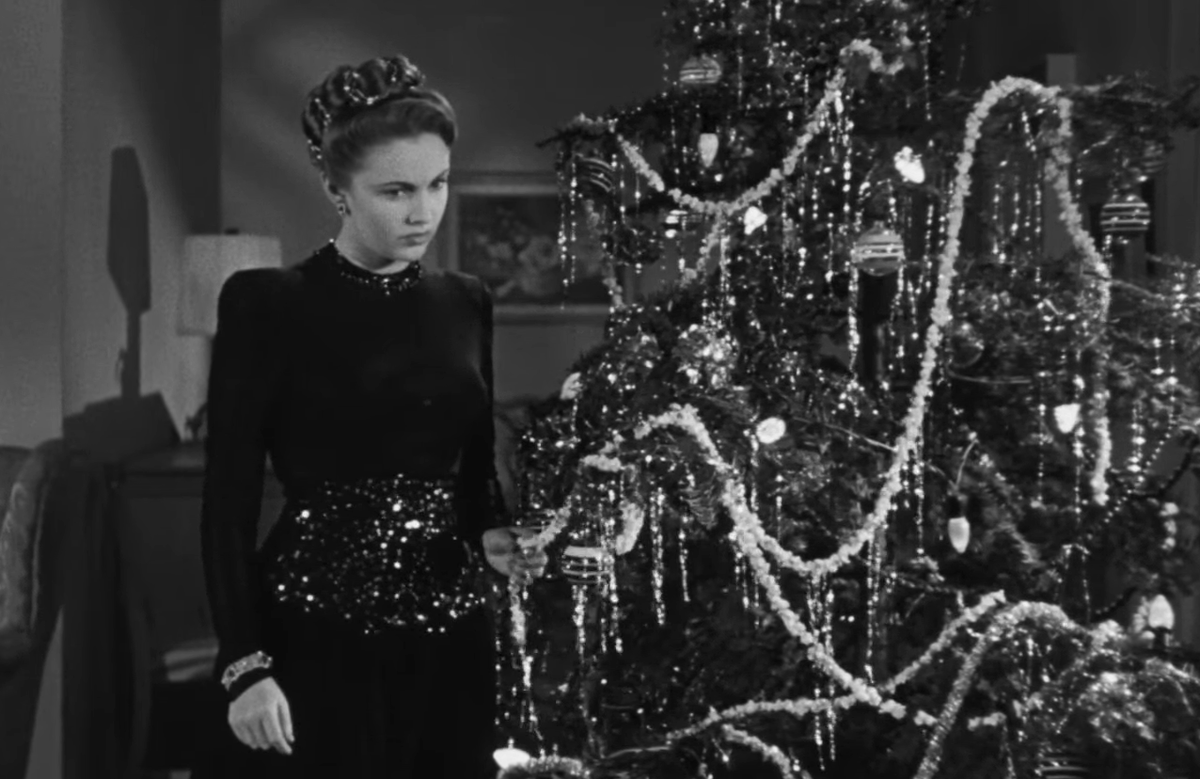 Кадр из фильма "Повторное исполнение": актриса Джоан Лесли в образе своей героини Шилы Пейдж наряжает ёлку в сценическом платье, дизайн которого разработал художник по костюмам Олег Кассини