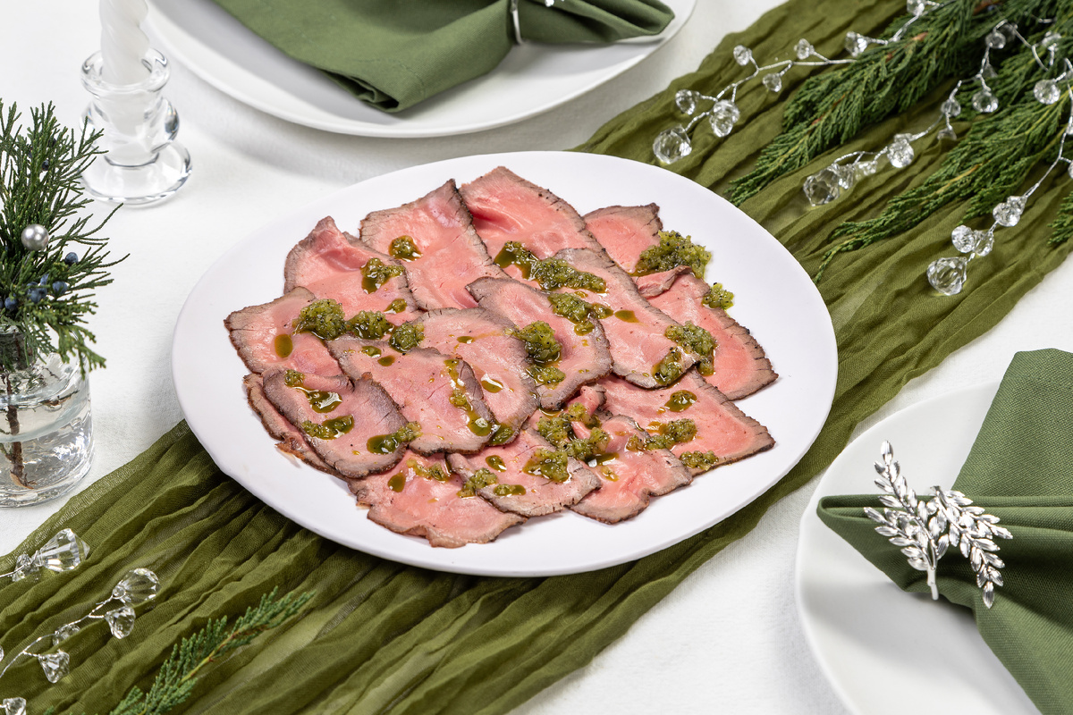 Ломтики нежной и аппетитной органической говядины травяного откорма, приготовленной по технологии су-вид. Подаются с еловым соусом.