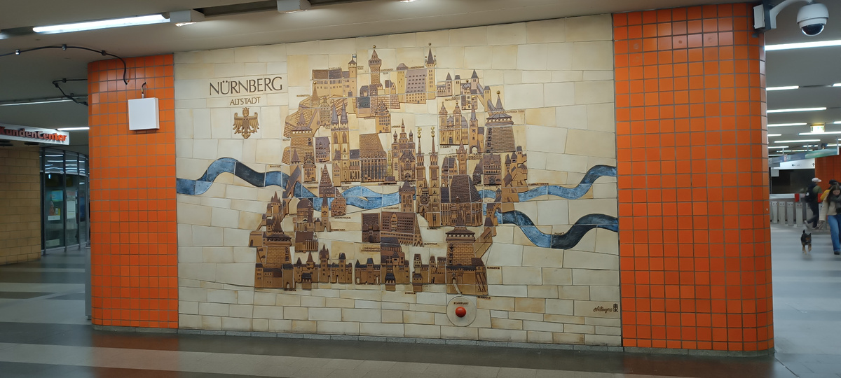 В отличие от Маннхайма, который расчерчен по квадратам как шахматная доска для перфекционистов, Нюрнберг — это лабиринт. Зато какой красивый! В подземном переходе нашел вот такую керамическую карту Альтштадта (Старого города). Жаль, у меня с собой не было кого-то в доспехах, малявка в своём модном прикиде смотрелась на этом фоне как попаданка в фэнтези-мир 😄.