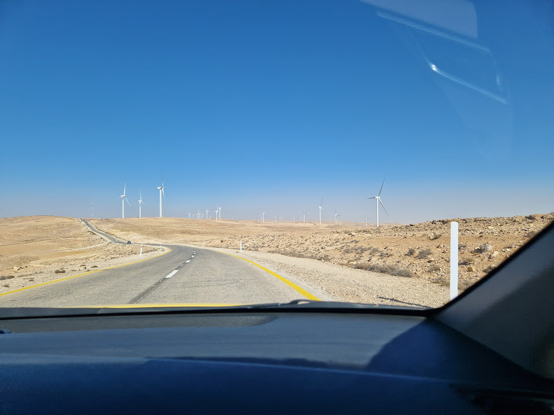 Вид через лобовое стекло машины. По сторонам часто видны ветряки, с их помощью ближайшие деревни снабжаются электричеством.