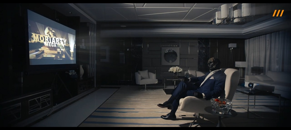 Мориарти сидит в роскошном кресле, как киногерой. На экране проектора — заставка “Moriarty Mega”. Это создание визуального якоря: “Я — это кино”. Он стирает грань между вымыслом и реальностью, чтобы вы забыли, что перед вами преступник, а не актер.