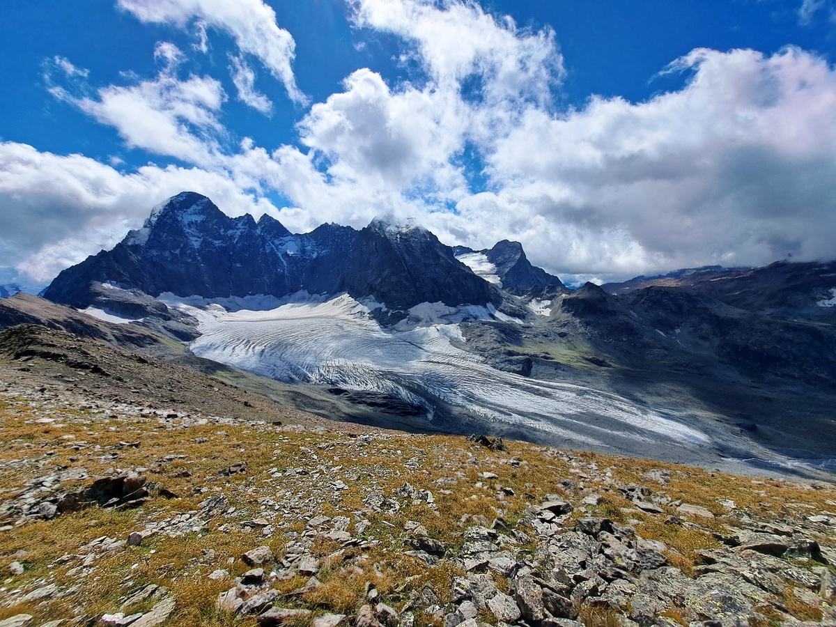 Внизу под ногами расстилается белое ледяное поле Марухского ледника. Над ним нависает громада Каракаи. А там за ледником – Марухский перевал – тот рубеж, где наши солдаты с августа 1942 по январь 1943 года стояли насмерть, не пропустив фашистов к морю. Вид с Красной горки.