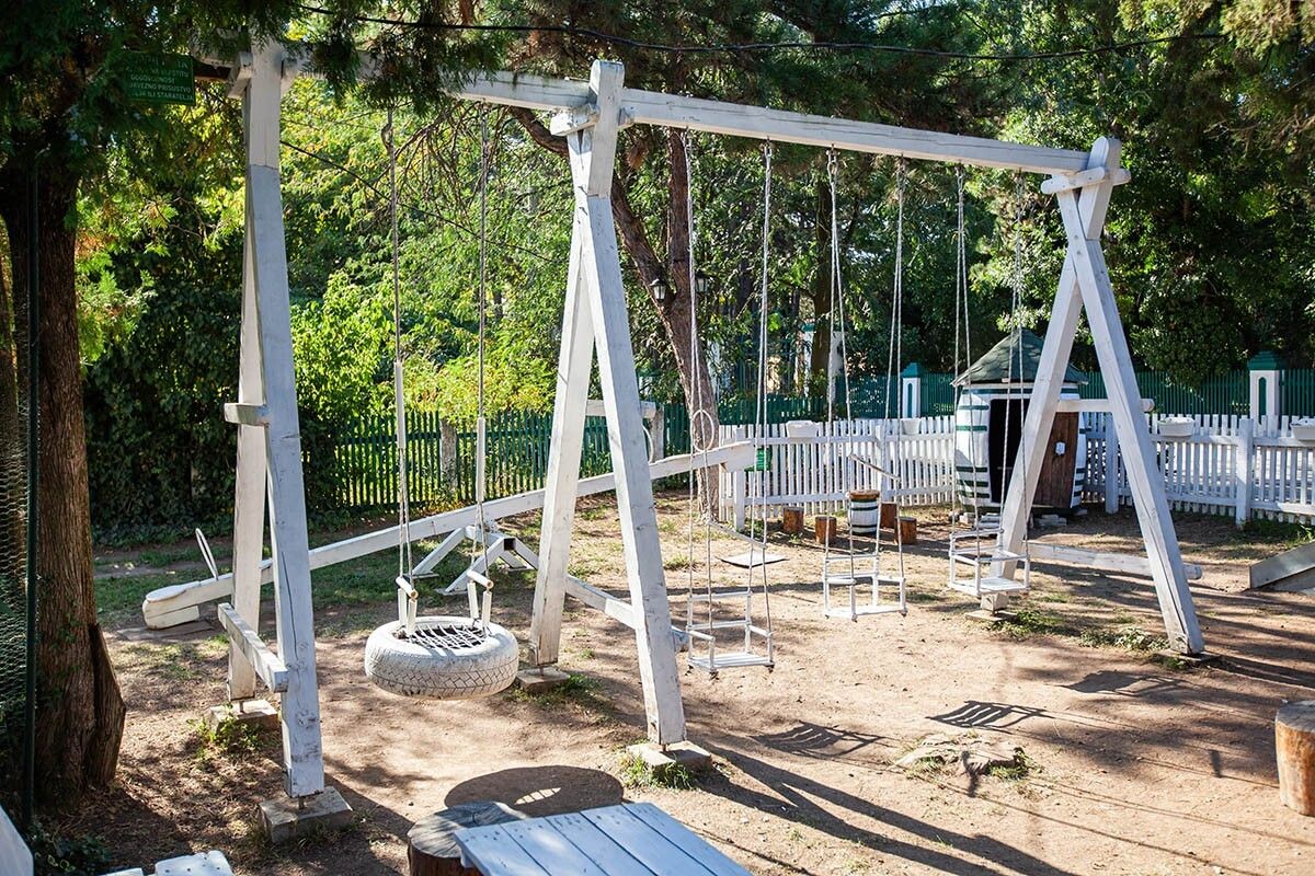 На переднем плане А-образные качели из бруса, на заднем — балансир. Источник: Mita Stock Images / Shutterstock / FOTODOM📷
