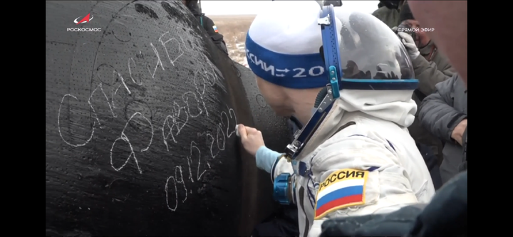 Кадры с прямой трансляции. Командир Сергей Рыжиков Оставляет автограф на корпусе спускаемого аппарата 