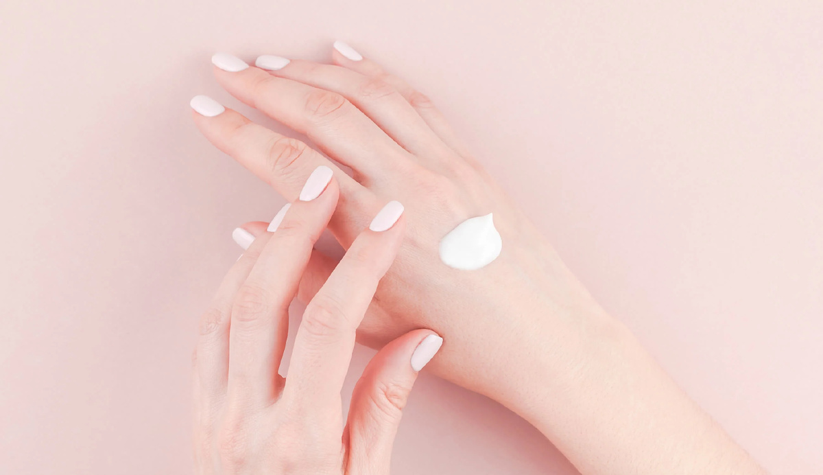 руки косметолога, аккуратно наносящие крем на кожу