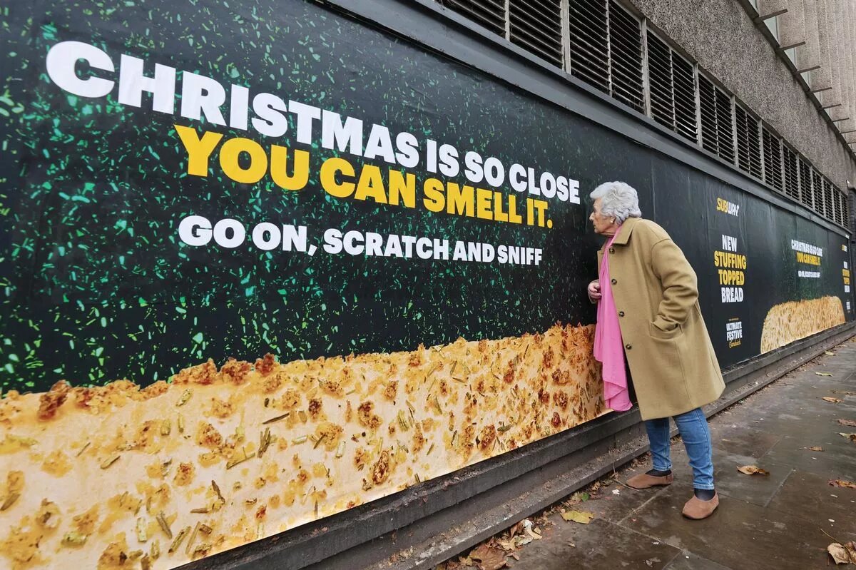 Надпись на баннере: Рождество так близко, что ты можешь его понюхать! Продолжай, потри и понюхай!