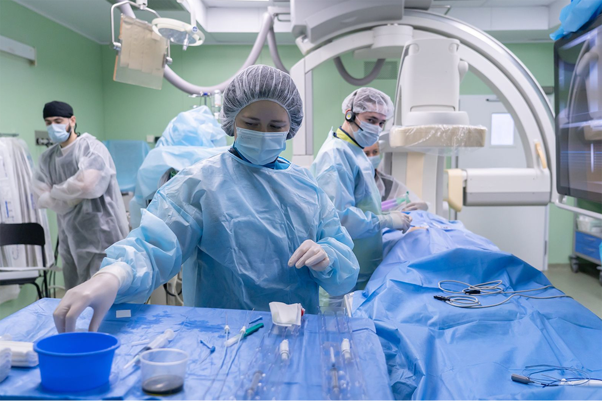 Медицинский персонал в полной хирургической экипировке работает в операционной детской кардиохирургии