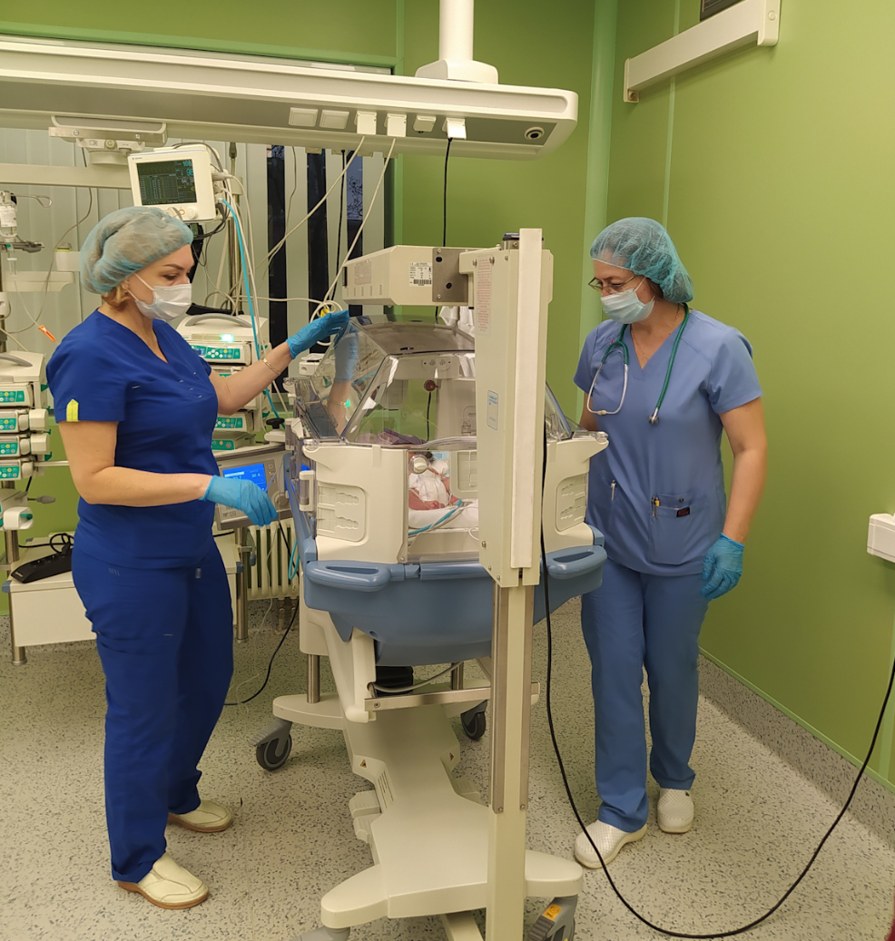 Медицинские работники наблюдают за новорожденным в детском отделении интенсивной терапии