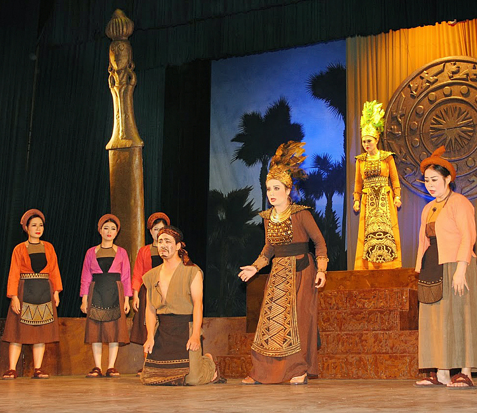 Сцена из оперы Тео «Королевы из Мелиня». Главное действующее лицо данной сцены – младшая сестра Чынг Ни – исполнительница её роли почти в центре, правее на возвышении – исполнительница роли старшей сестры Чынг Чак.