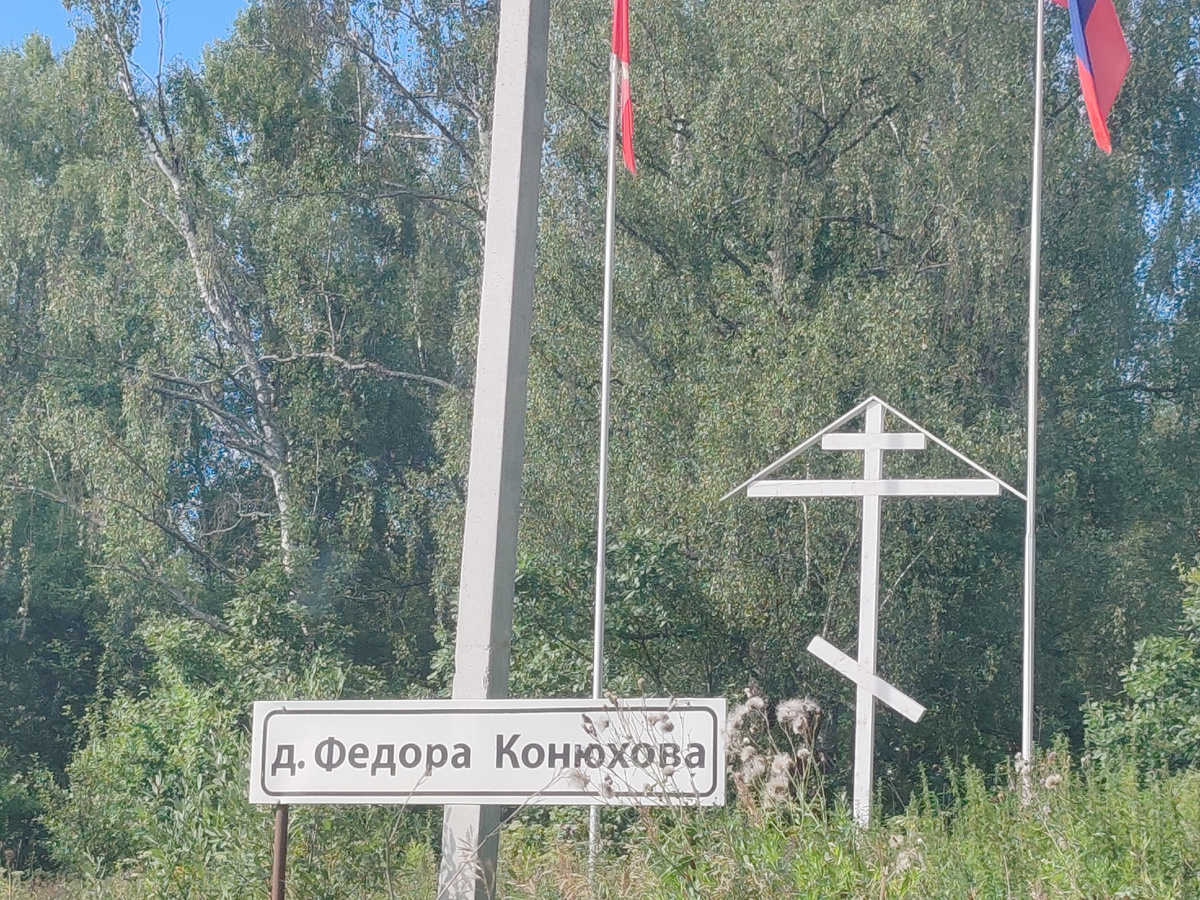 указатель "д. Федора Конюхова". Такие кресты стоят по дороге. 