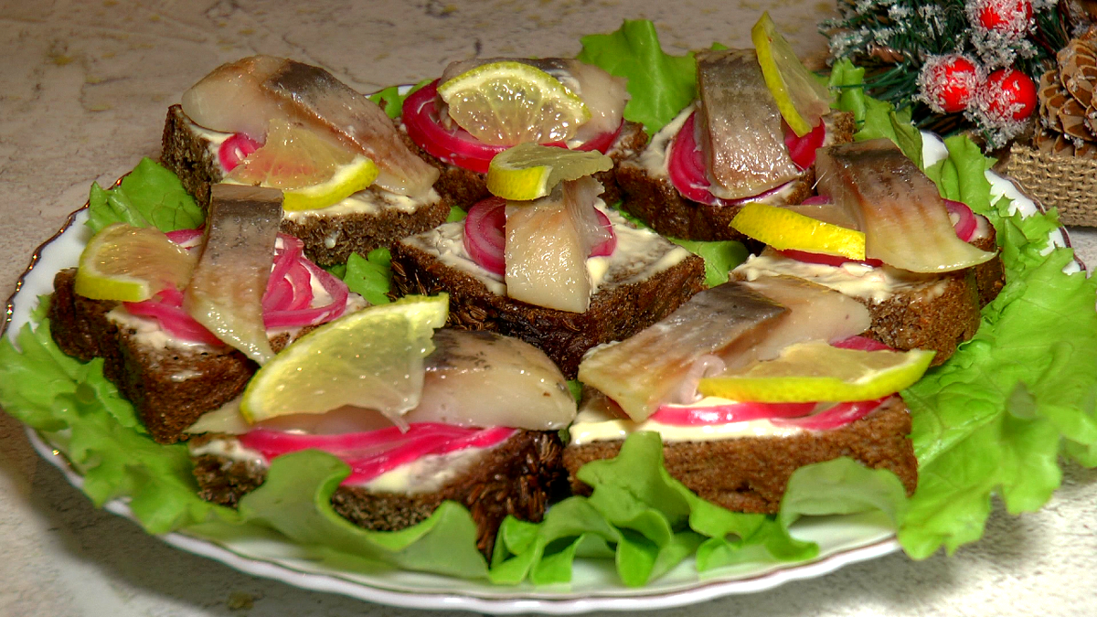 Закусочные бутерброды с селедкой, маринованным луком и лимоном