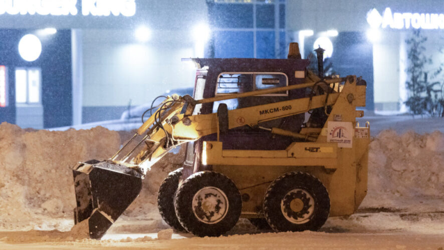    Сотрудники коммунальных служб во время уборки снега на дороге.