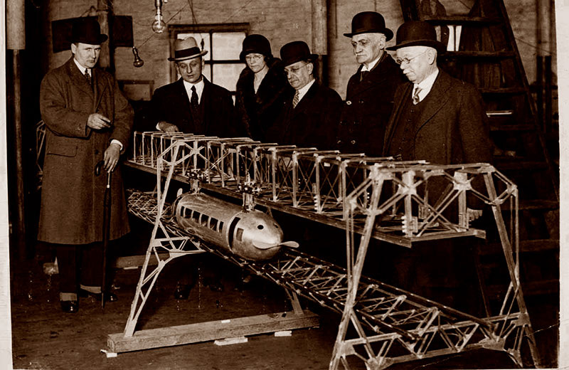 Джордж Бенни (первый слева) демонстрирует модель предложенной им системы, около 1928 года.