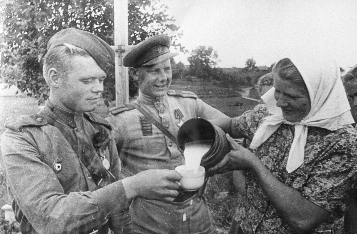 Латвийская женщина угощает молоком красноармейцев, 1944 год