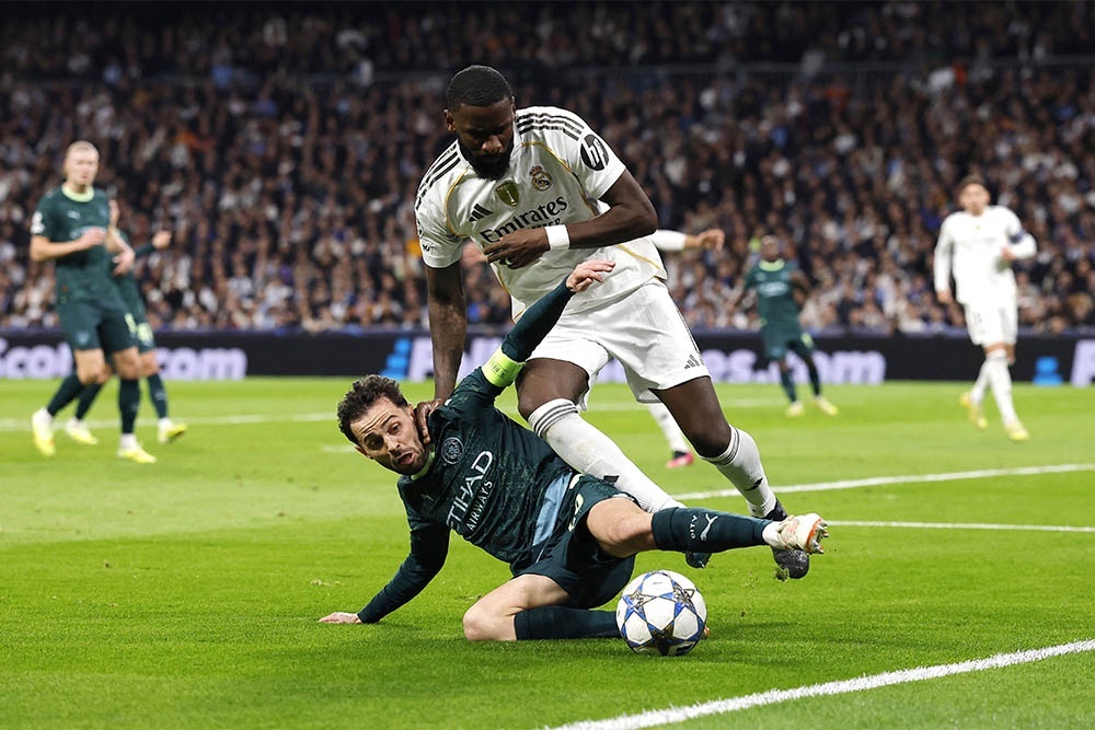    Игроков "Манчестер Сити" было не сломить: Бернарду Силва в подкате отбирает мяч у мощного Антонио Рюдигера. / REUTERS