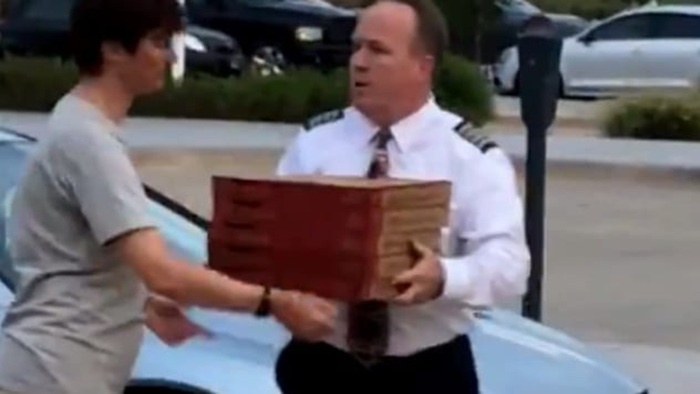 Кадр из видео, на котором пилот разносит заказанную им пиццу для пассажиров его рейса.