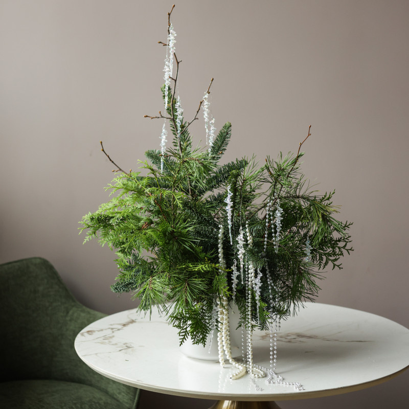 Композиция их разных хвойных веток, украшенных бусами