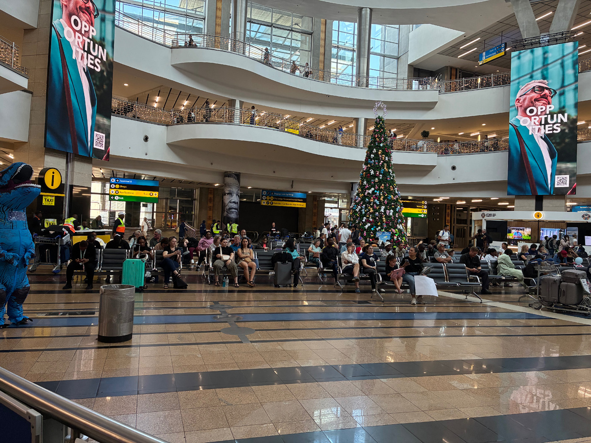 Зона прибытия в аэропорту Йоханнесбурга. Аэропорт сегодня носит имя Орландо Тамбоза (Orlando Tambo International Airport), или сокращенно ОЛТА (OLTA). Раньше он носил имя Яна Смэтса, но в результате отмены апартеида в 2006 году был переименован.