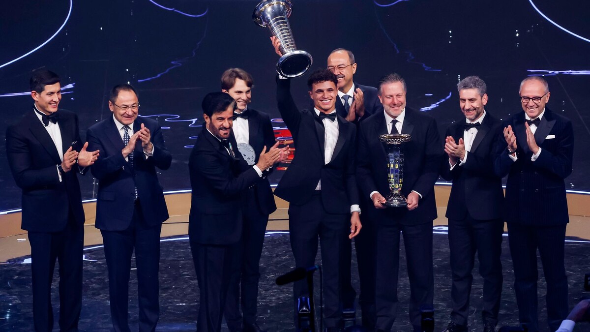 Норрис поднимает над головой чемпионский кубок