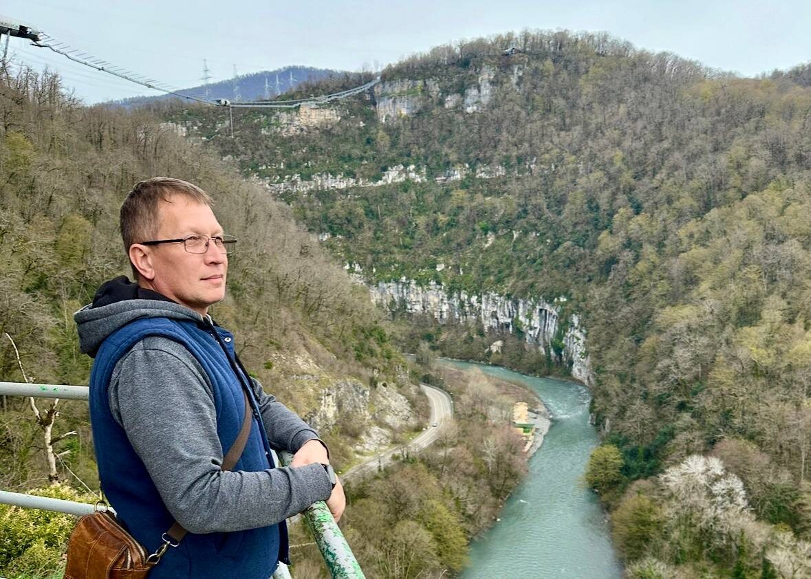 На заднем фое видно скайпарк (Влад стоит рядом со входом в пещеру)