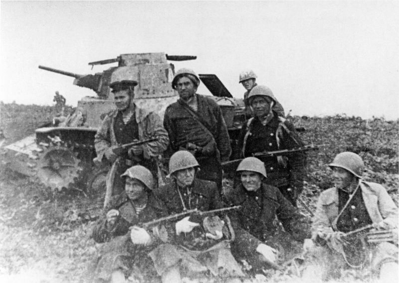 Бойцы сводного батальона морской пехоты Петропавловской военно-морской базы Тихоокеанского флота (командир — майор Тимофей Алексеевич Почтарев), действовавшего в группе первого броска десанта в операции по захвату о. Шумшу, на фоне подбитого японского танка Тип 95 «Ха-Го».
