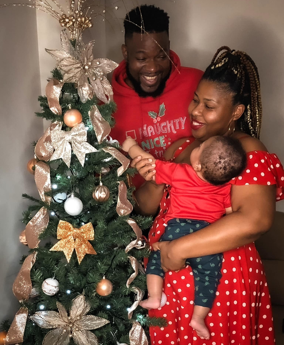 Тринидадский певец и продюсер лейбла Righteous Кристофер Майерс, известный как Малыш Крис (Baby C) - с женой и ребёнком и Рождественской ели