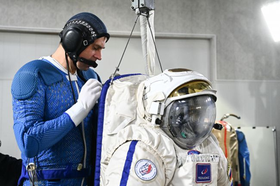 Андрей Федяев входит в скафандр на стенде «Выход-2». Фото: ЦПК