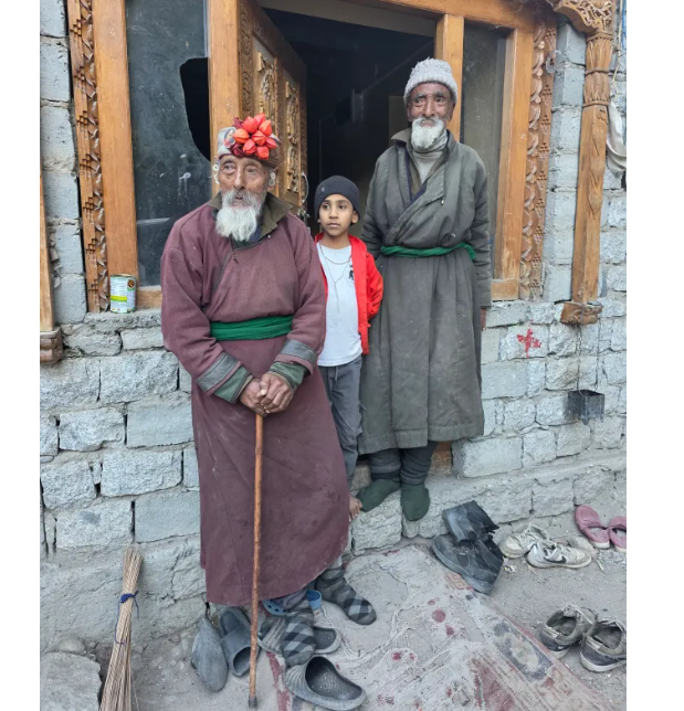 Местные старики возле каменного дома и очень красивого окна с разбитым стеклом