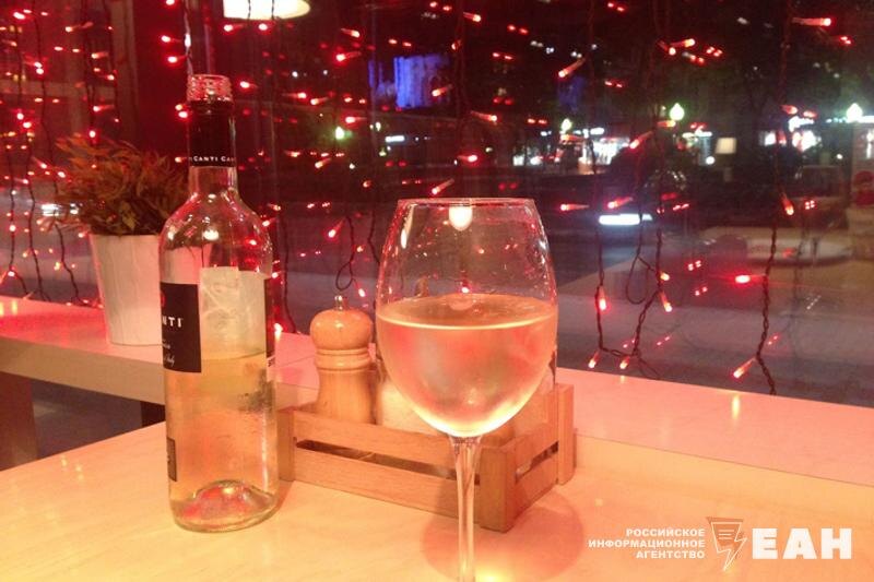    Вино в бокале и бутылка на столе