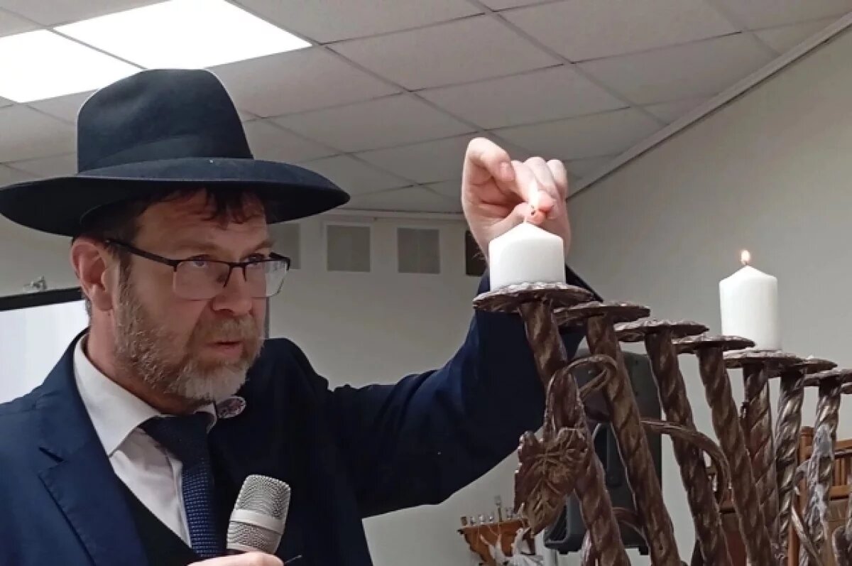    Ариэль Масалитин зажигает первую свечу в восьмисвечнике-меноре.