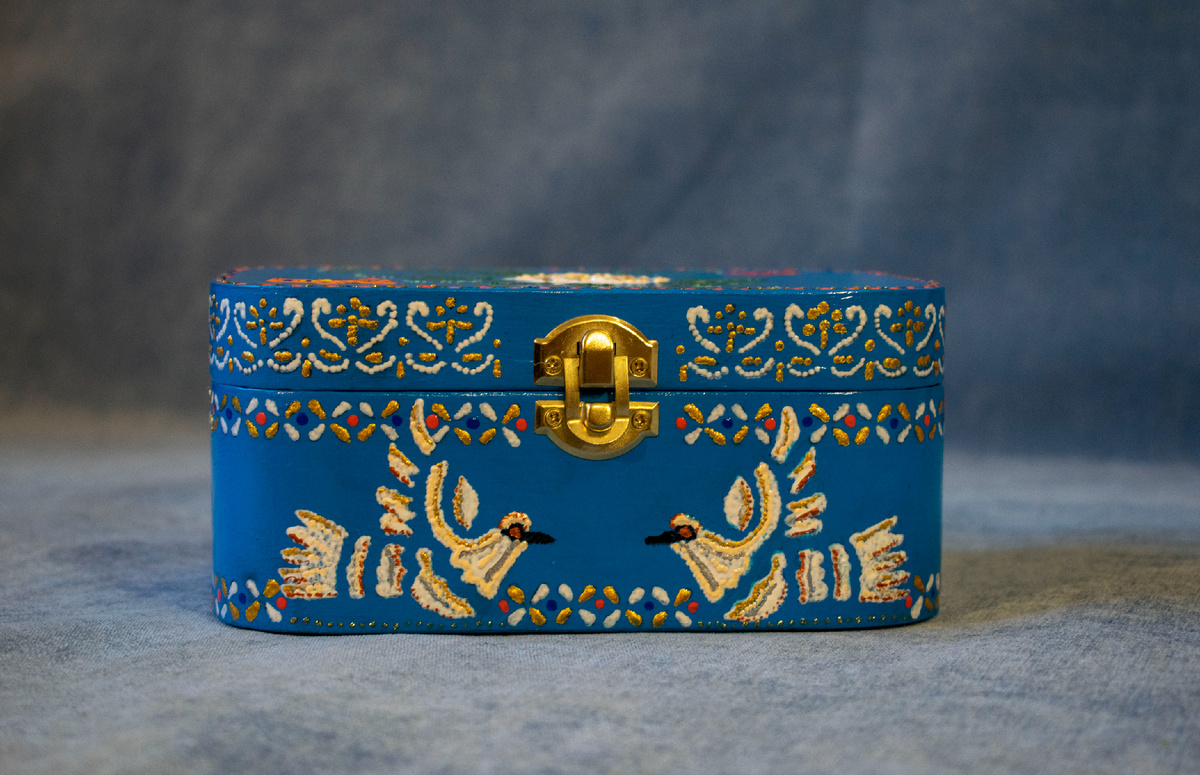 Деревянный сундучок «Райский сад» расписала Виктория Михалина 10 декабря 2025 года в технике точечной росписи. В композиции шкатулки изображены белые птицы, узорчатый орнамент по верхнему и нижнему корпусу сундучка. Фотография автора статьи.