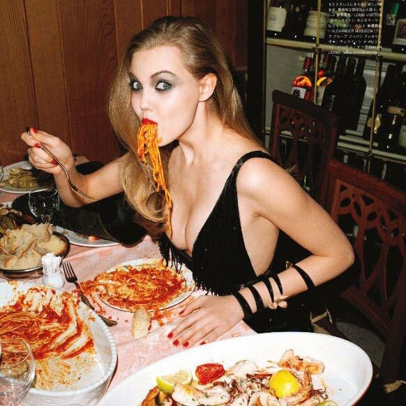 Девушка жадно ест за столом на свидании, пока мужчина смотрит с удивлением. Иллюстрация к статье о феномене "тарелочницы"