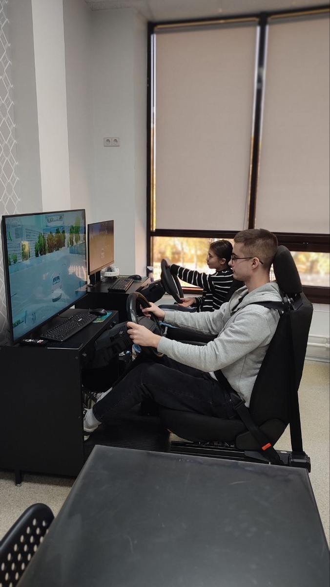 
Некоторые плюсы такого подхода:

Безопасность — обучение на тренажёре безопаснее, чем на реальном автомобиле, в случае ошибки или аварии водитель не рискует своей жизнью и здоровьем, а также не создаёт угрозы для окружающих участников дорожного движения.

Имитация реальных дорожных условий — тренажёр позволяет моделировать городские улицы, автодром.

Отработка навыков движения по дороге — трогание и остановка у светофора, змейка, разворот, заезд в бокс, параллельная парковка, эстакада и другие.

Освоение стандартных двигательных комбинаций. Правильная работа рулём, педалями, селектором коробки передач.

Ключевой принцип обучения на тренажёре — многократное повторение действий. На их основе вырабатывается начальная мышечная память на правильное руление, педалирование, переключение передач и другие элементы.

Именно поэтому наш преподаватель берёт за основу проезд того или иного упражнения по три раза минимум.

Упражнения, многократно повторенные и закреплённые действием, превращаются в стойкий навык управления автомобилем.

Также тренажёр позволяет:
Сократить время инструктора на обучение основным приёмам работы с органами управления автомобиля — сформировавшиеся на тренажёре навыки помогают ученику сосредоточиться на вождении учебного автомобиля.
Контролировать и оценивать качество сформированных практических навыков и теоретических знаний, фиксировать ошибки, допущенные курсантом при вождении, и возможность их разбора.

Ошибки - это нормально, но получив практику на тренажёре этих ошибок будет чуть меньше в реальных условиях.