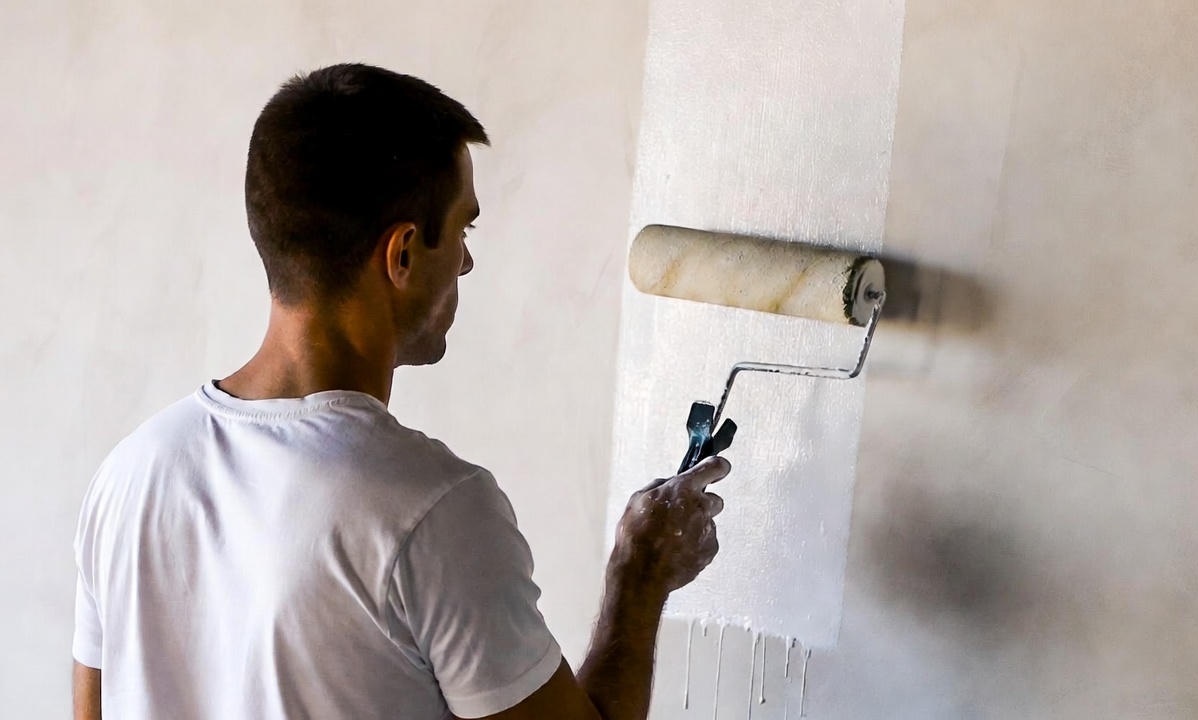 Фото 2: Нанесение краски валиком на стену