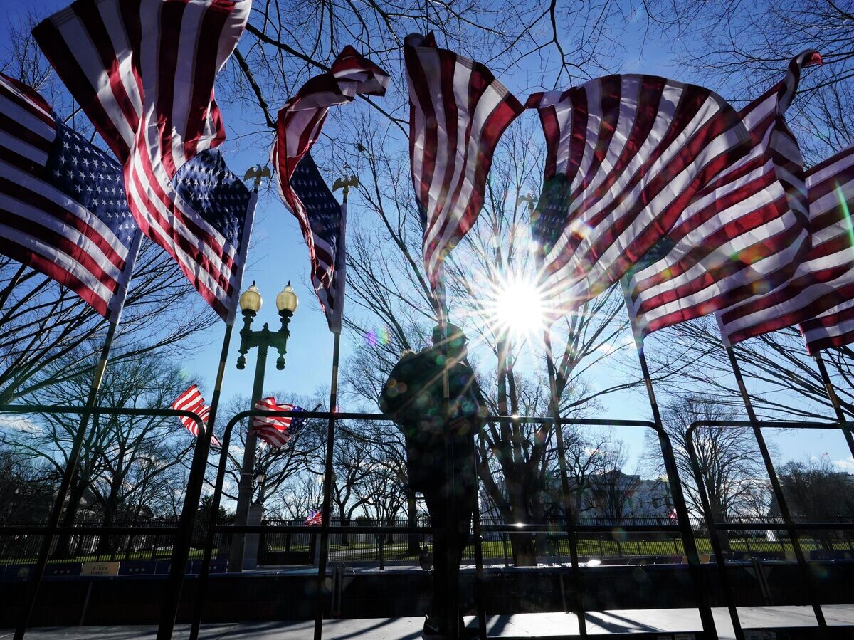    Рабочий устанавливает американские флаги в Вашингтоне | © AP Photo / David Phillip