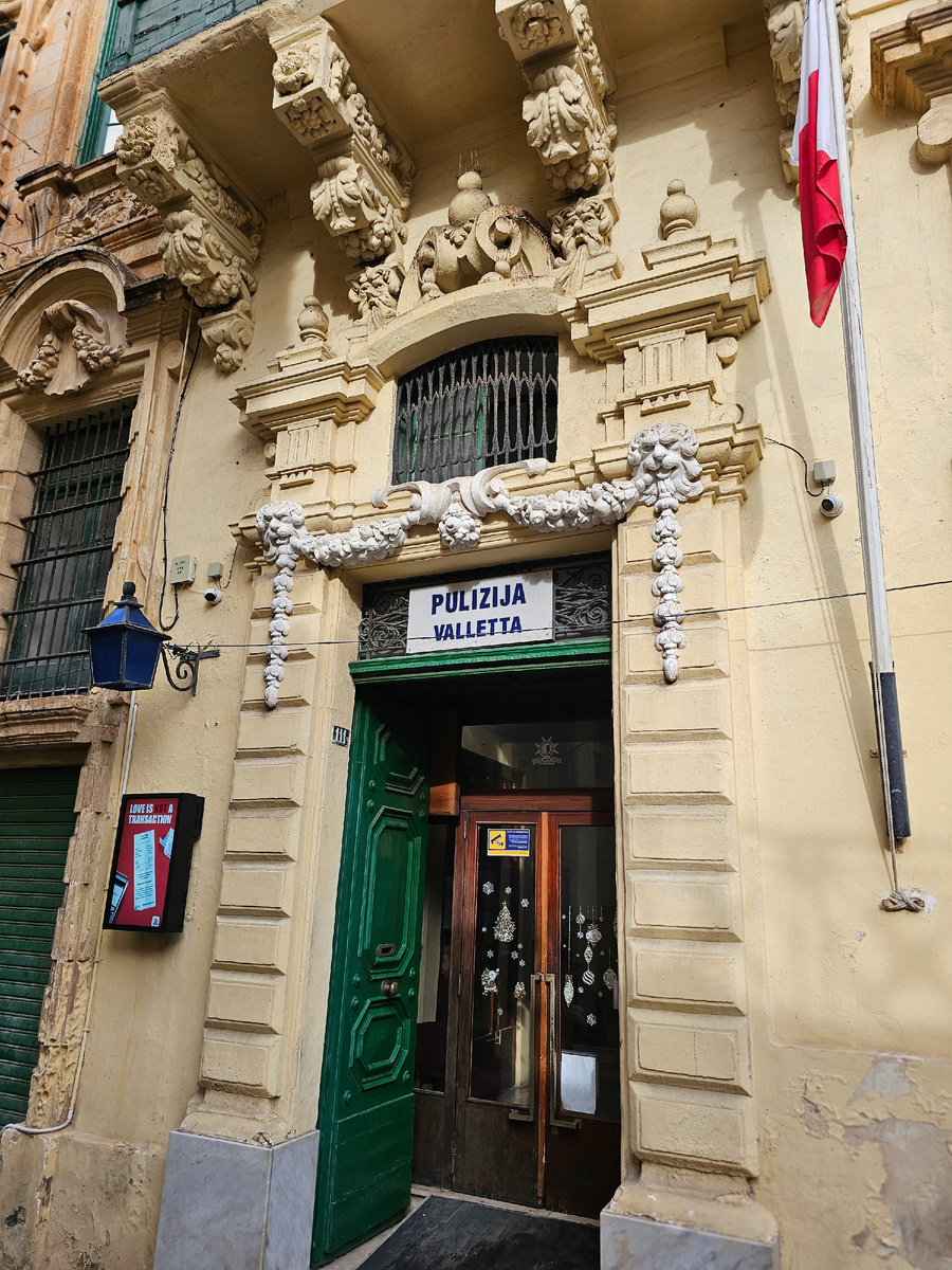 Вход в полицейский участок. Синий фонарь, красно-белый флаг и много-много новогодних украшений