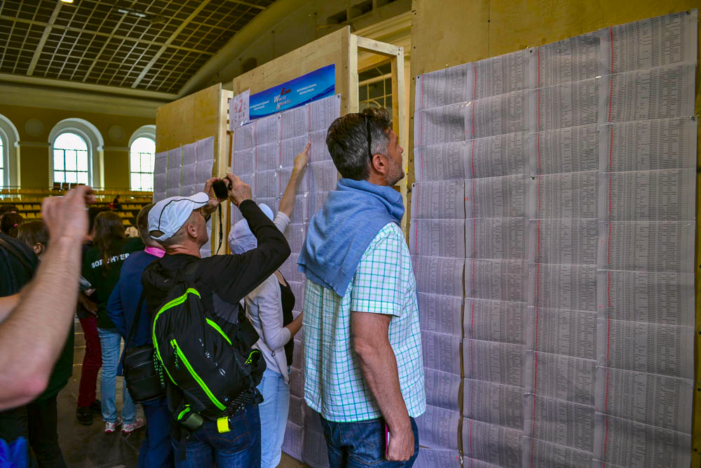 Чтобы получить стартовый конверт участника сначала нужно найти себя и свой номер в длинных списках.