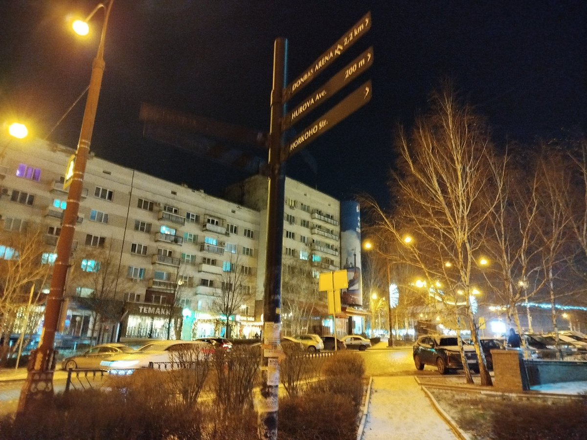 Уличный указатель и новогодние огни в начале проспекта Ильича.