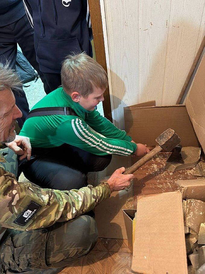 Мальчик и взрослый мужчина измельчают воск