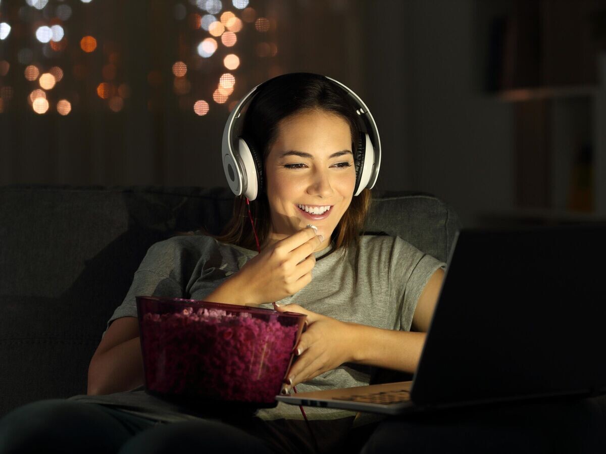    Девушка смотрит видео в наушниках | © iStock.com / AntonioGuillem