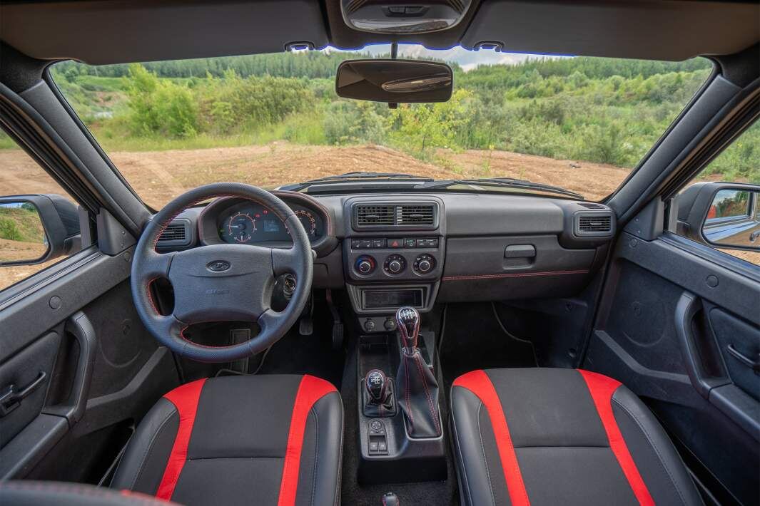 Niva Sport щеголяет красно-черной отделкой интерьера. В салоне автомобиля исчезли все подстаканники, зато внедорожник из Тольятти впервые получил регулировку руля. Правда, только по углу наклона
Фото: ИЗВЕСТИЯ/Борис Ульзибат