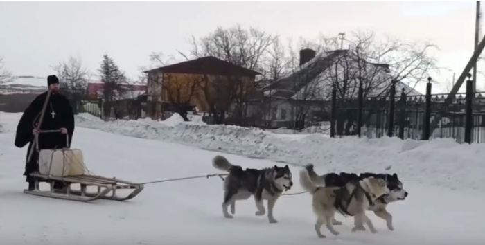 Отец Андрей везёт с родника в храм канистры с водой. На счёт водопровода в Эвенске пока не очень / Скриншот кадра видео Юрия Гришана