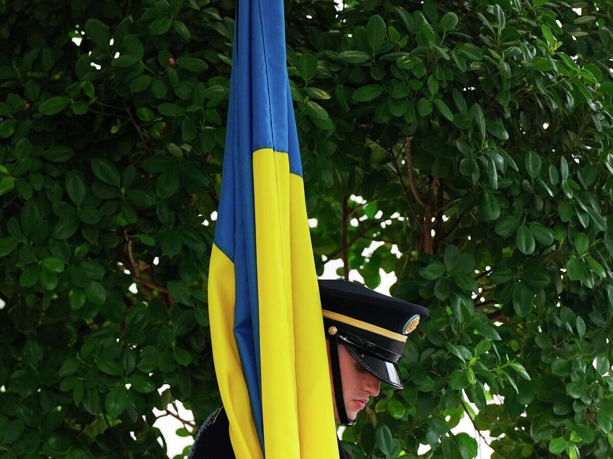    Военнослужащий почетного караула с флагом Украины перед встречей Дональда Трампа и Владимира Зеленского в Вашингтоне | © AP Photo / Julia Demaree Nikhinson
