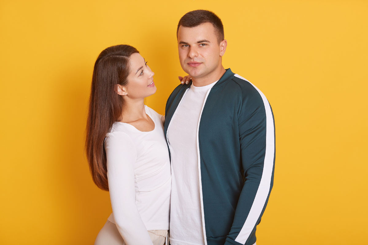 Мужчина и женщина стоят рядом на жёлтом фоне, девушка смотрит на партнёра с теплом, символ благодарности и ценности отношений