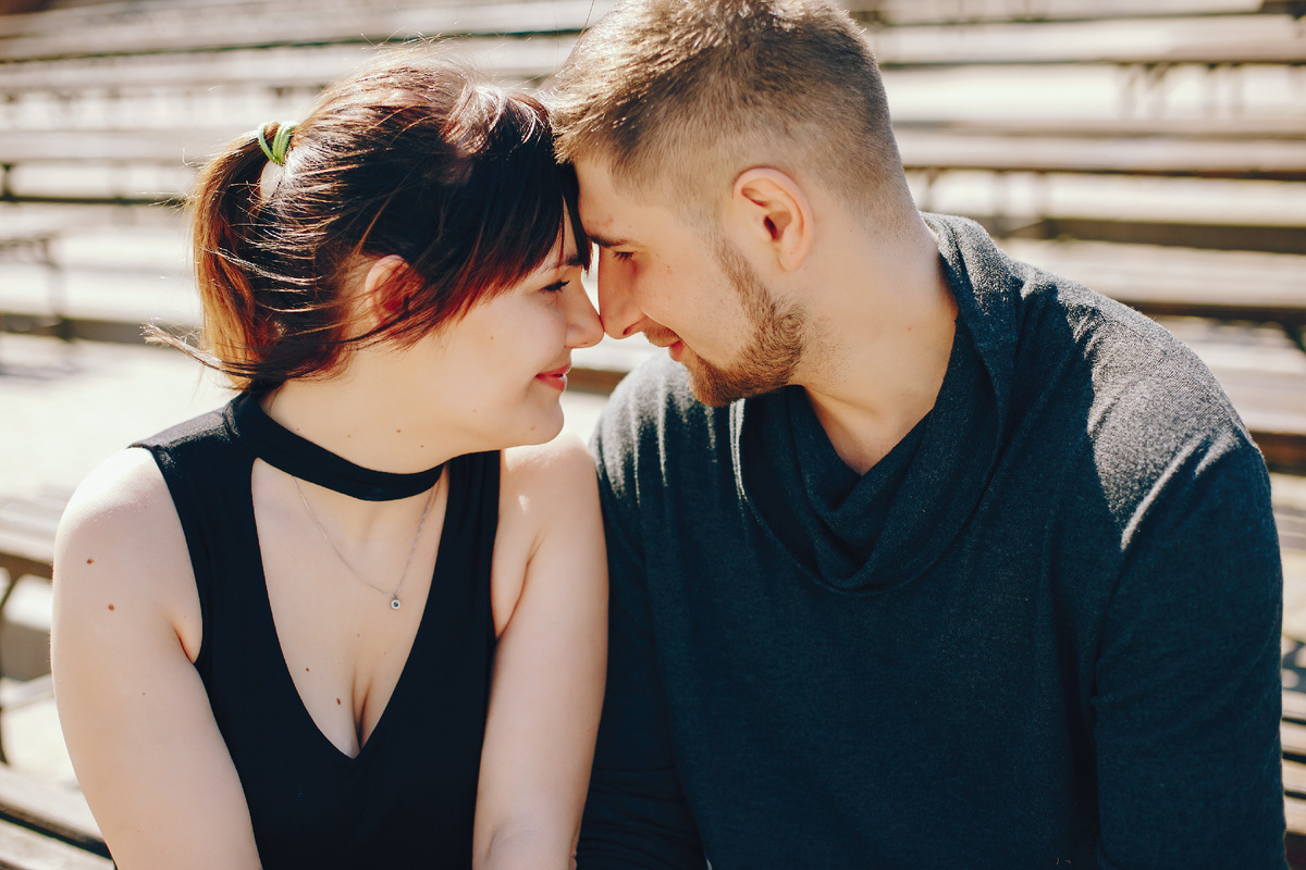 Мужчина и женщина сидят рядом и смотрят друг на друга, момент близости и доверия в отношениях, несмотря на скрытность партнёра