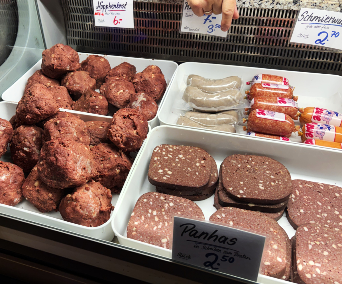 На фото, запечатлена "мясная" витринана одной из вестфальских рождественских ярмарок. На переднем плане - два вестфальских мясных специалитета - кровяная колбаса. Из крови, шкурок, внутренностей с добавлением  различных круп или (и) ягод.  Здесь тоже, наверное, находятся скучающие по голодной жизни... Фото моё.