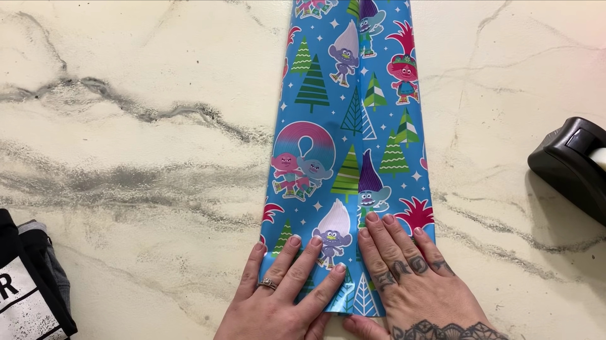    Шаг 2. Выньте вещь и соедините скотчем упаковку в нескольких местах. Так бумага не порвется в процессе.YouTube / Jami Swan