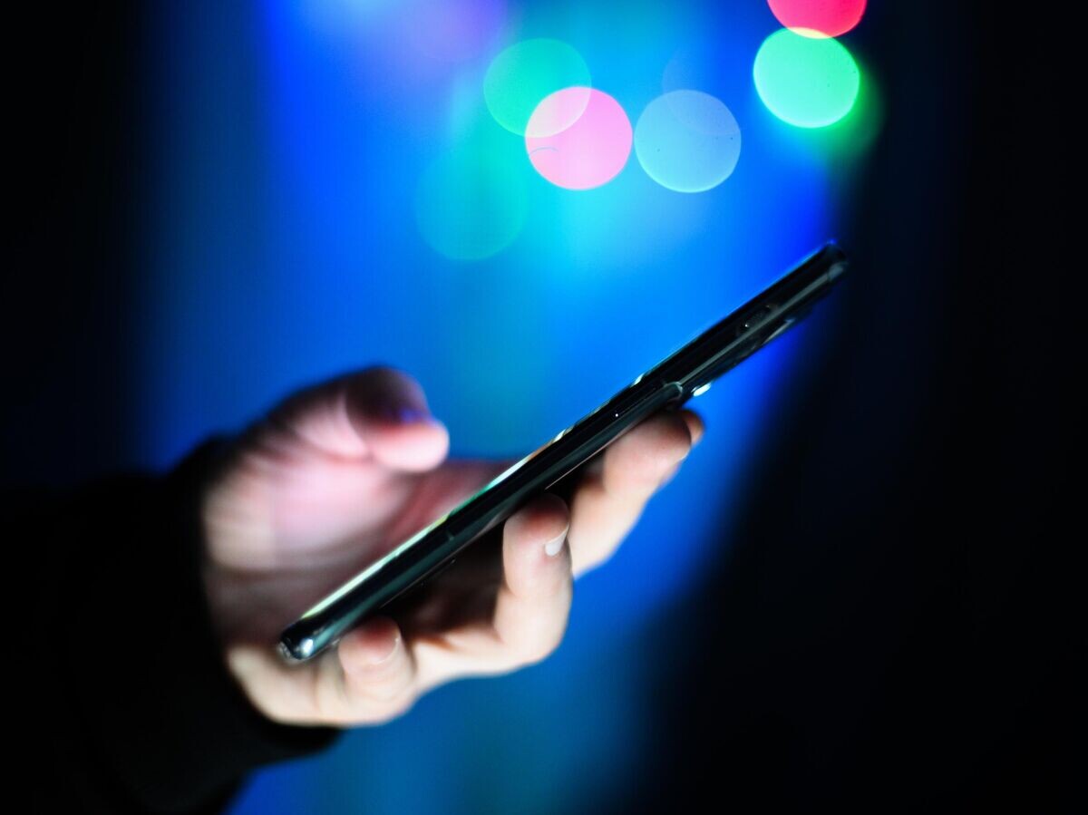    Мужчина держит в руках мобильный телефон | © РИА Новости / Владимир Астапкович